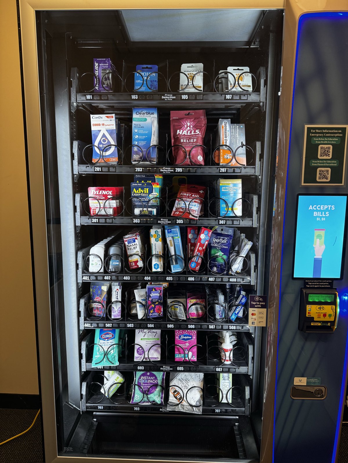 Vending machine with product selection buttons, pricing displays, and multiple stocked shelves